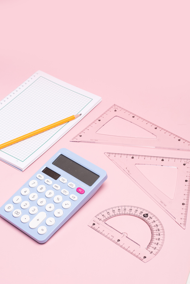 Calculator and Geometry Ruler on Pink Background